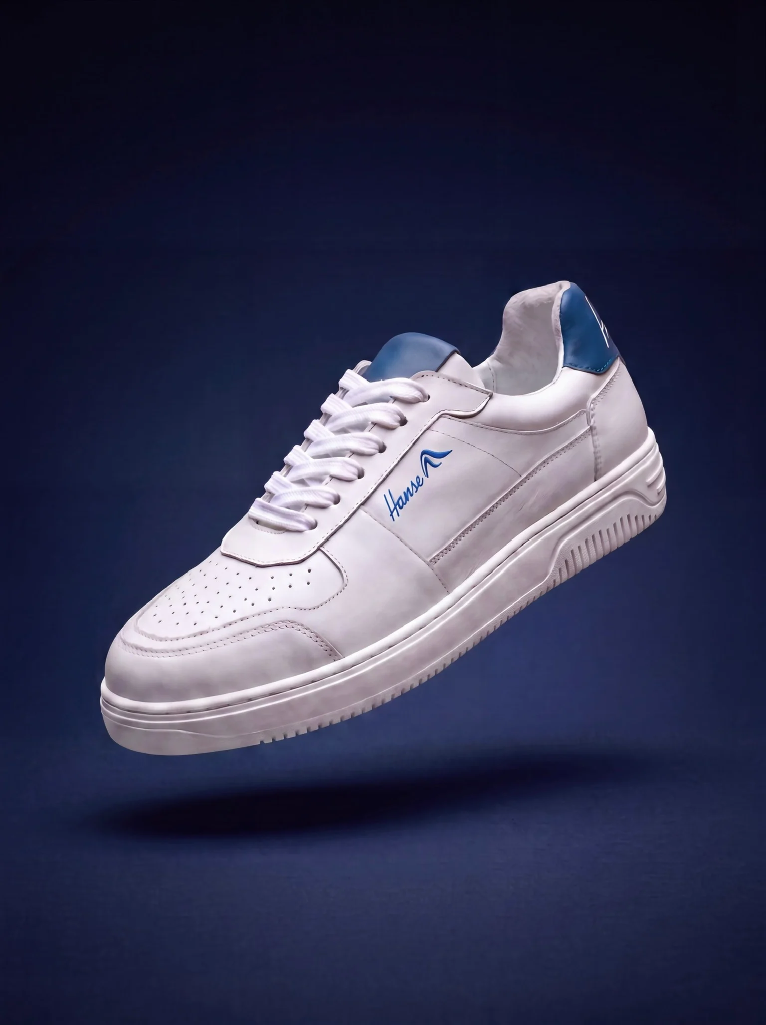 HanseYachts Firmensneaker aus Vollleder vor dunkelblauem Hintergrund